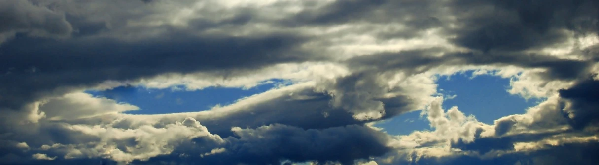 clouds moving in opposite directions, with a blue sky and white cloud in the center