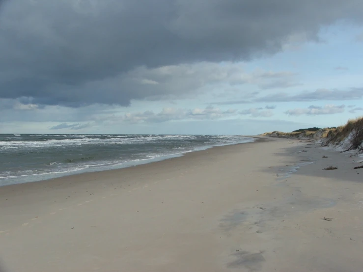 a cloudy day with waves crashing in to the shore