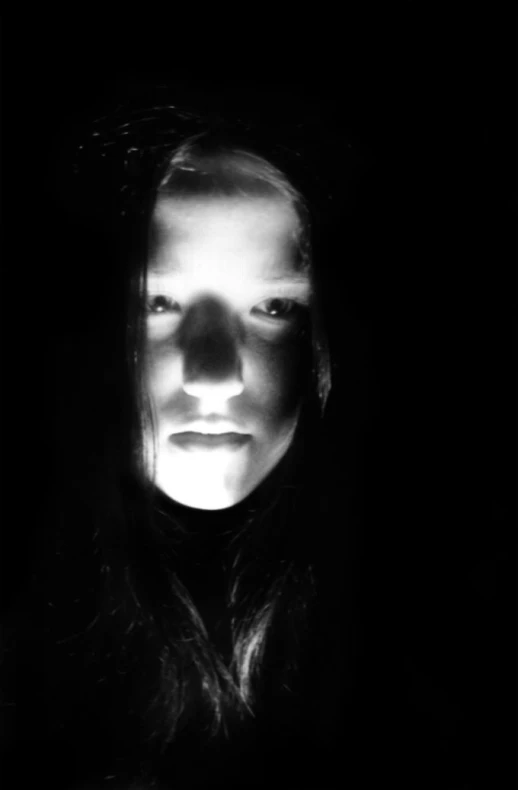 a girl is captured in black and white with shadows
