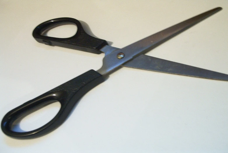 a pair of black scissors sitting on top of a table