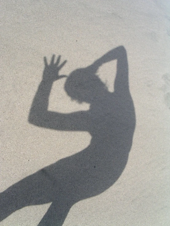 shadow of a woman doing handstand on the ground