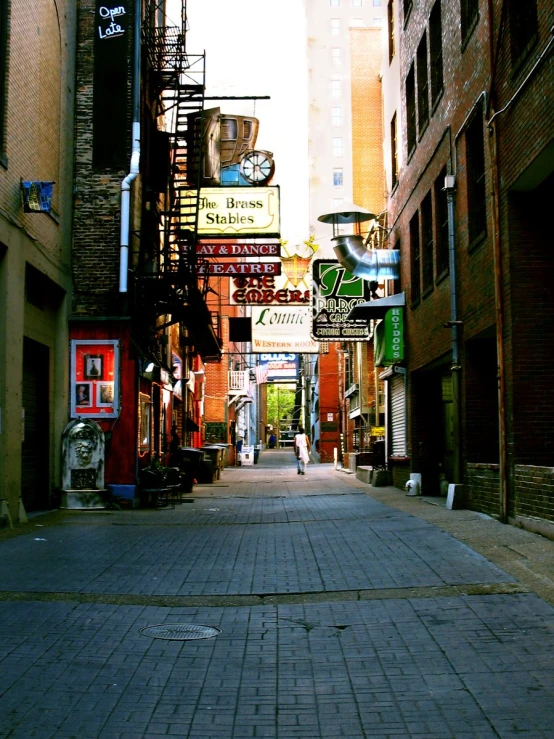 a bricked street that has various business signs on buildings