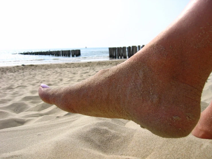 a person standing on top of sandy beach