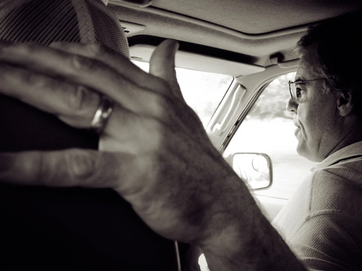 a black and white po of a man driving in his car