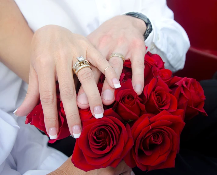 a woman holding two roses on her left hand