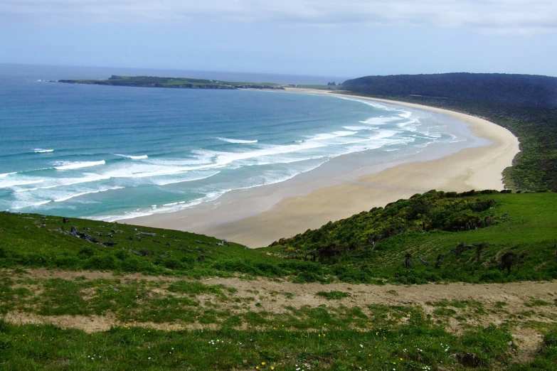 a grassy hill overlooks a large body of water