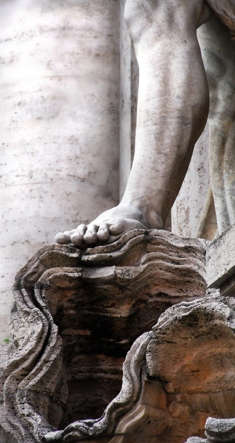 statue in center of large sculpture holding rock type object