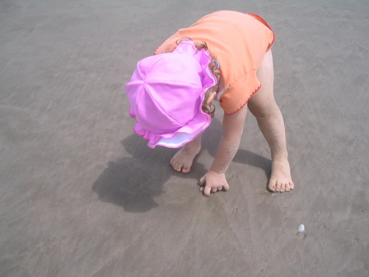 there is a little girl that is standing on the sand