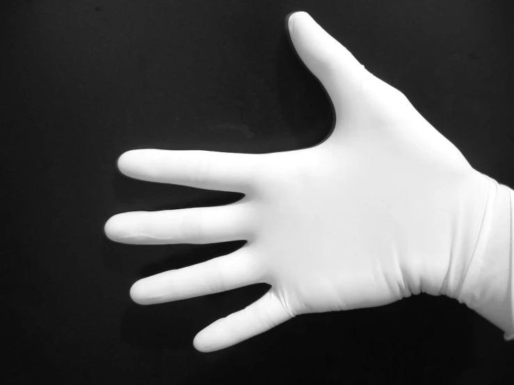 a white glove holds the bottom of a plastic hand