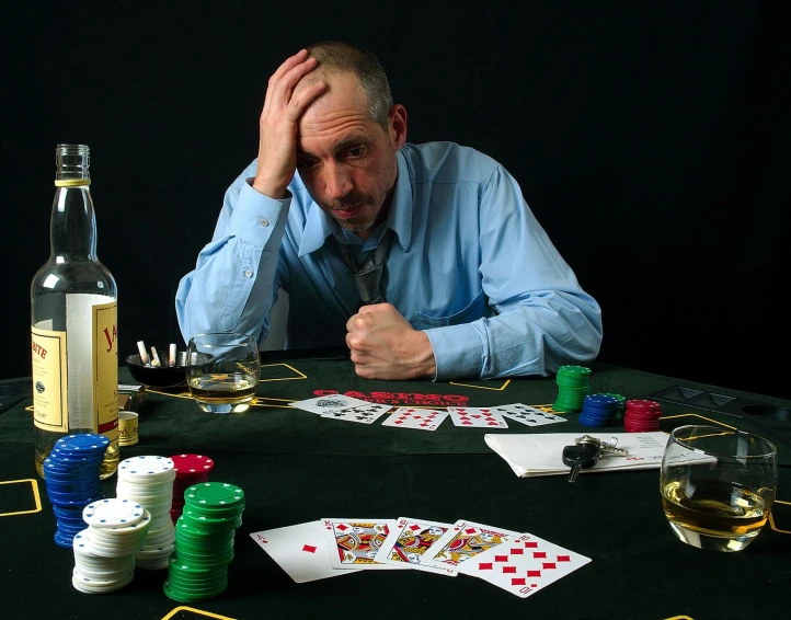 a man sitting at a poker table with poker chips and cards
