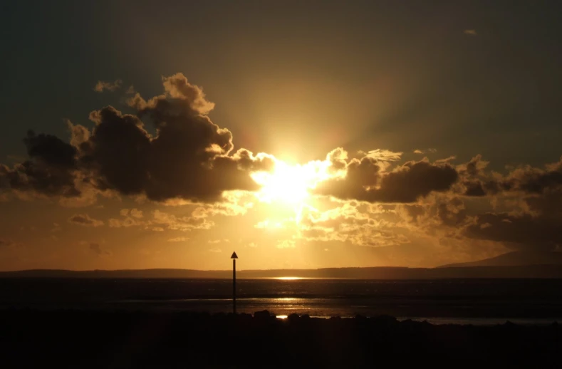 the sun shining brightly through the clouds on a dark day