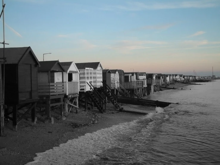 some old wooden beach huts next to the ocean