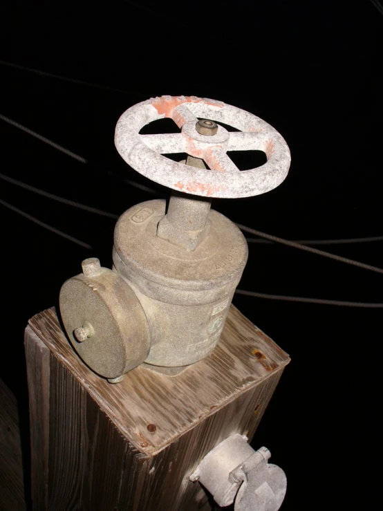 a fire hydrant on a wooden post in the night