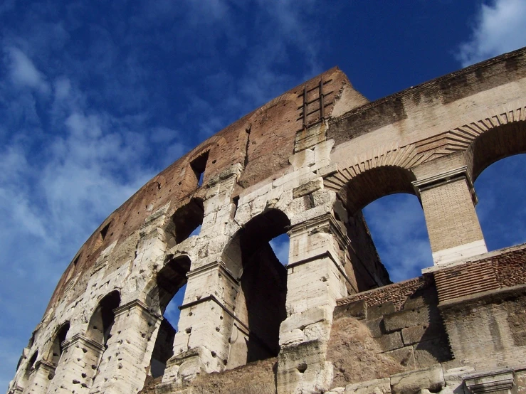 an ancient brick building with several arched openings and sky in the background