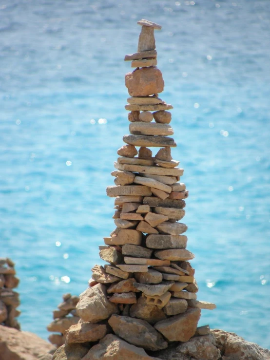 rocks and small rocks are stacked high in front of water