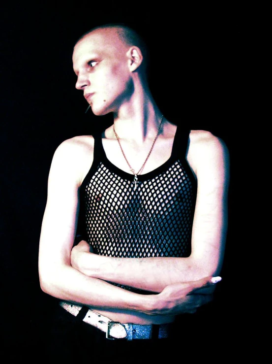 a bald man with black tank top is holding his arms crossed