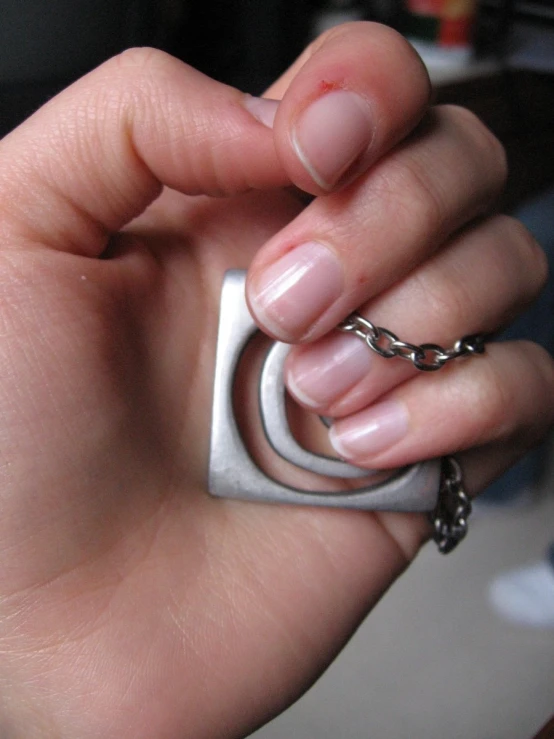 a close up of a person holding a silver ring