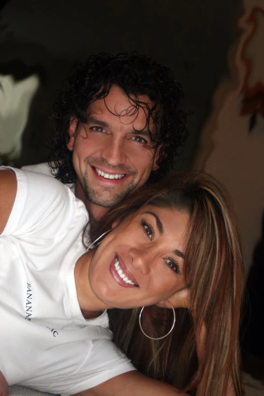 a man and woman smile as they pose together