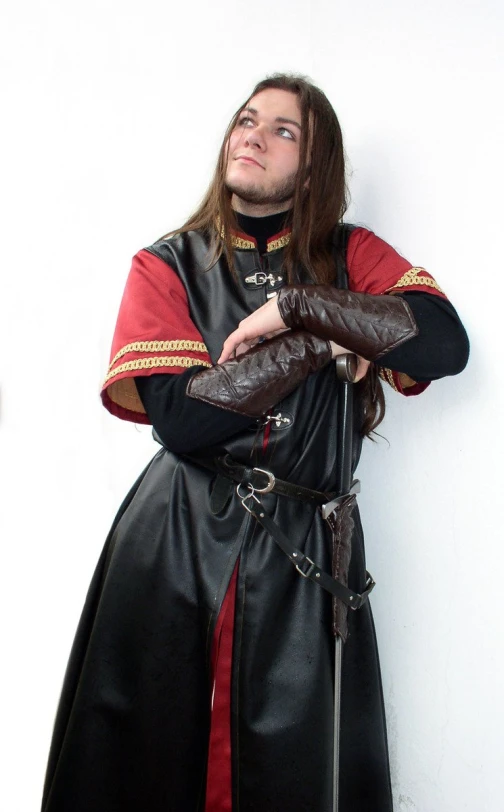 a man wearing medieval clothing and leather gloves