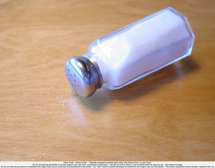 an empty bottle sitting on top of a wooden table