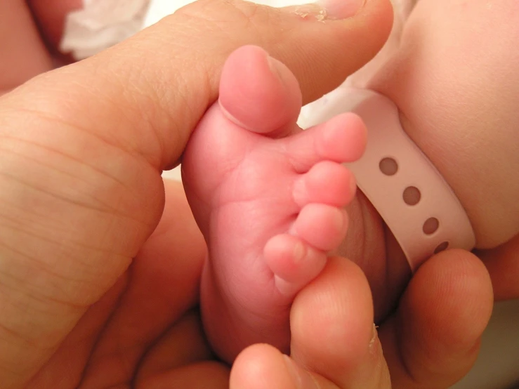 a person holding a newborn baby in their hands