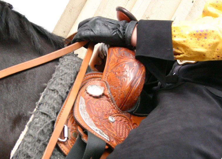 the arm of a person in gloves on a horse