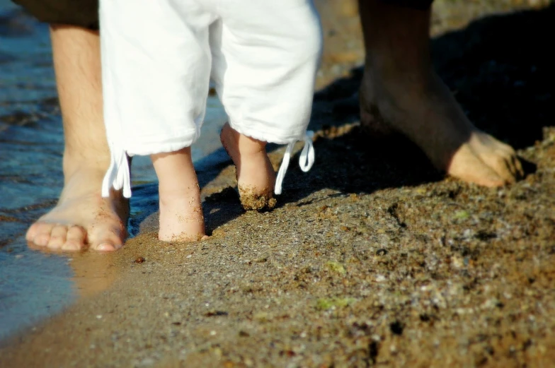 two people walking into the surf from their feet