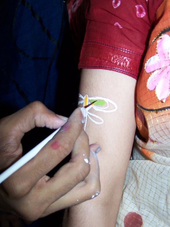 close up of a woman showing off her fake tattoos on her left arm