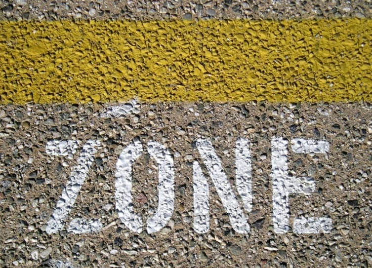 the word zone painted on asphalt on a street