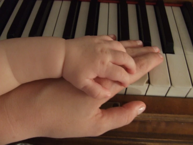 a baby playing on a baby piano with its hands