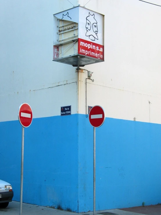 a blue wall with three street signs on it