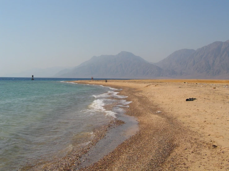 a large body of water sitting on the side of a beach