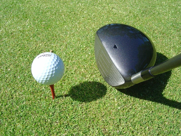 a golf ball is next to a tee on the grass