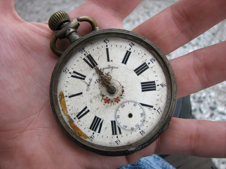 a man is holding his pocket watch with the hands