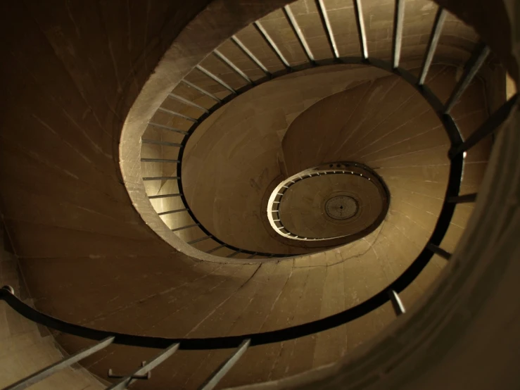 a spiral staircase at the bottom of a very tall building