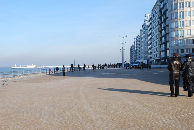 a man and woman standing on a path near the ocean