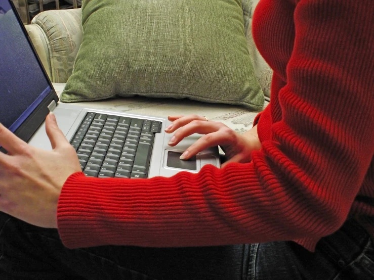 a young woman uses her laptop on her couch