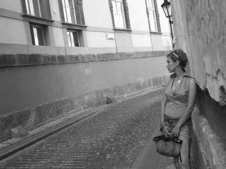 a woman walking down a street past two buildings