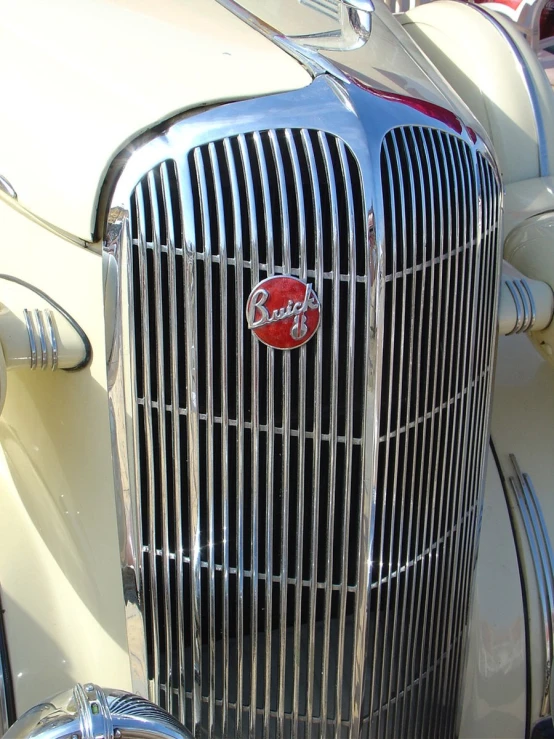 the front grill of a vintage car with chrome trim