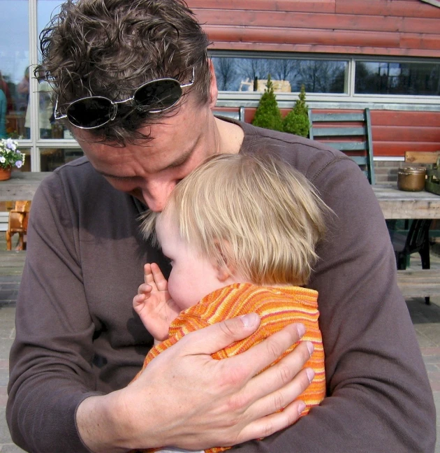 a man holding a  wearing shades on his face