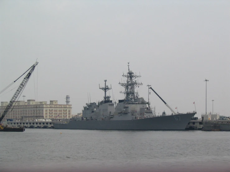 a large navy ship sitting in the harbor