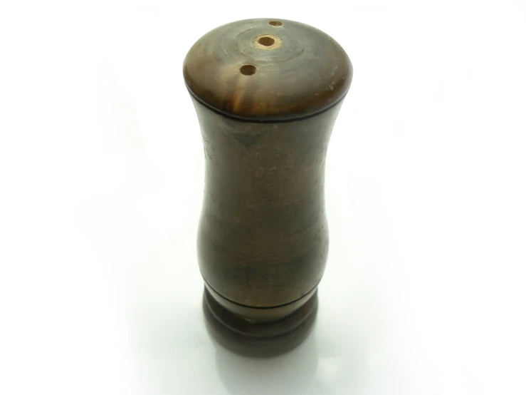 a brown vase on a white surface on a table