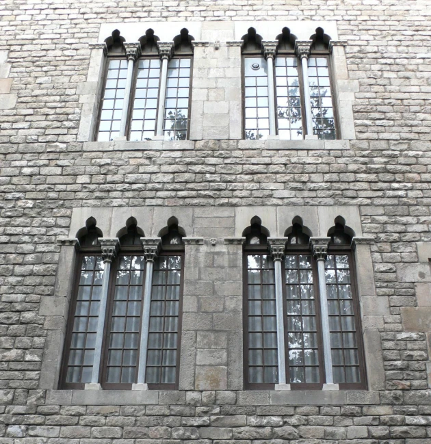 an old brick building with many windows and two clocks