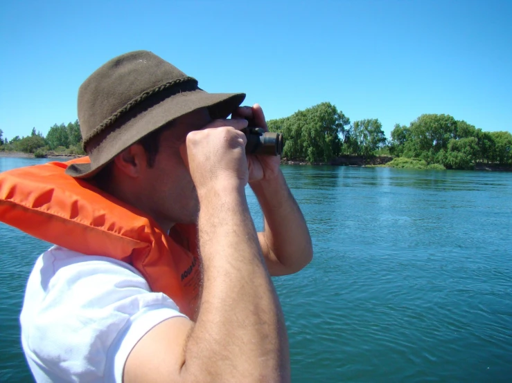 the man is looking through a telescope at the water