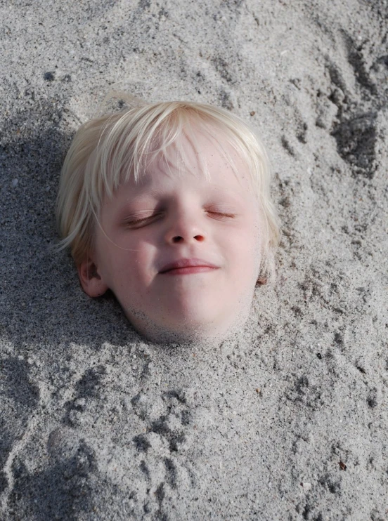 a young child that is asleep on the sand