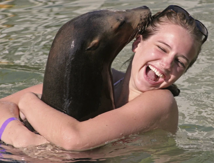 a girl holding an animal in the water