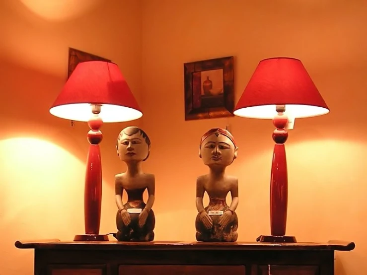 two sculptures are sitting on top of a dresser