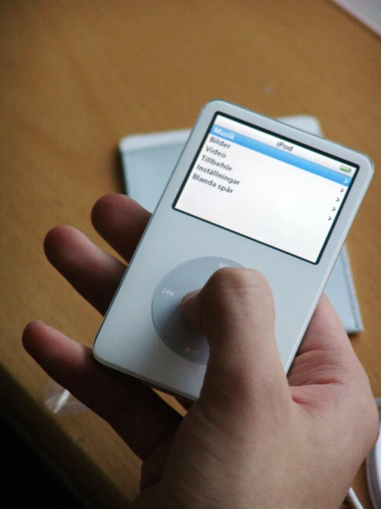 a person holding a cell phone next to a tablet