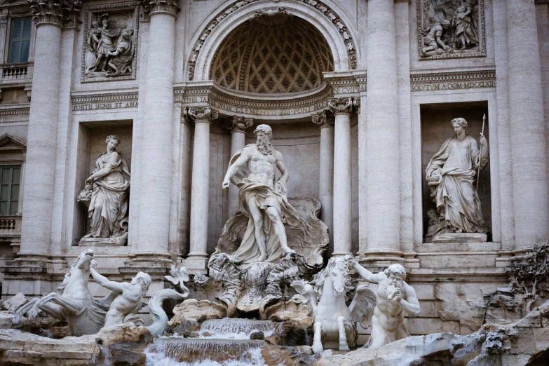 many statues are placed in a fountain near statues