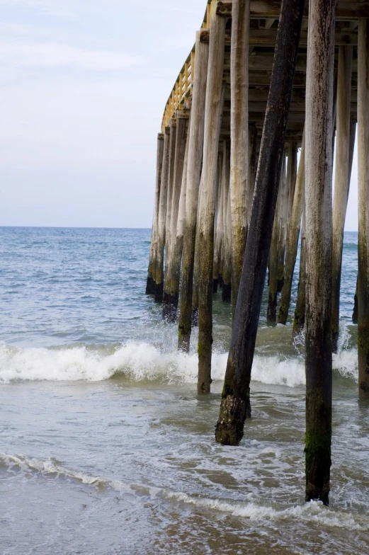 the ocean under a wooden pier and waves